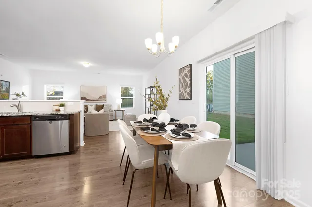 a dining room with furniture a chandelier and wooden floor
