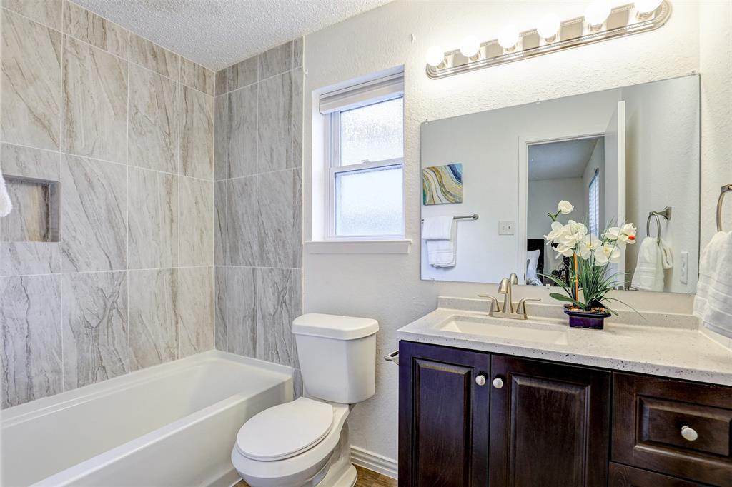 6005 Oak Hill Road Watauga, TX 76148 - Photo 15 of 22 a bathroom with a sink a toilet a mirror and shower
