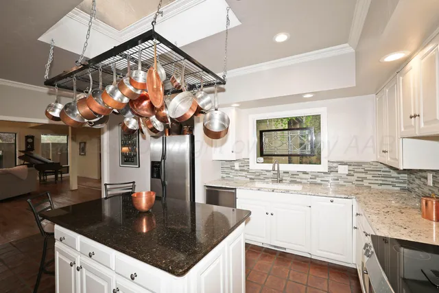 a kitchen with a sink a counter top space cabinets and stainless steel appliances