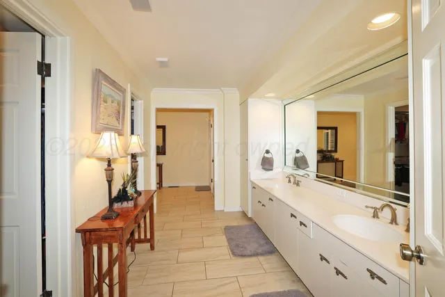 a large bathroom with a glass door shower and a sink