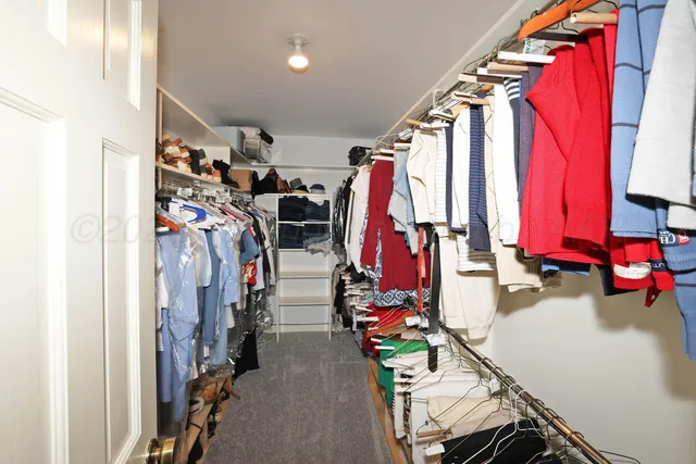a view of walk in closet with clothes
