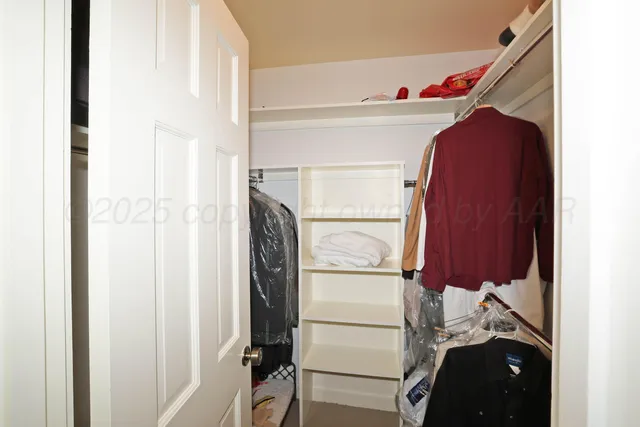 a view of walk in closet with clothes and shoes