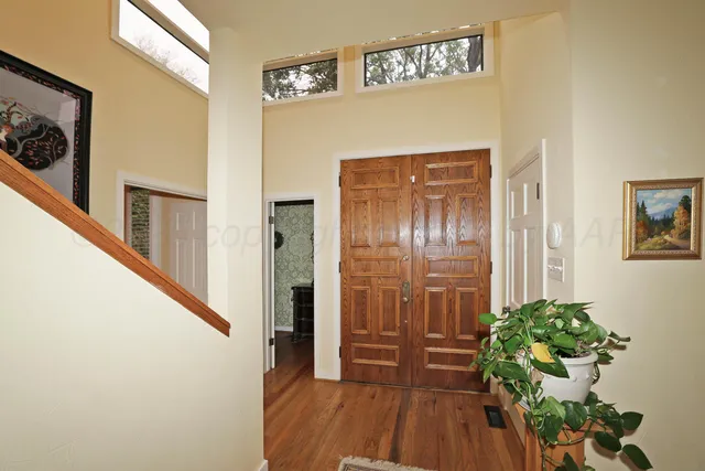 a view of a hallway with wooden floor and stairs