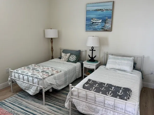 a bedroom with two beds and a lamp on dresser