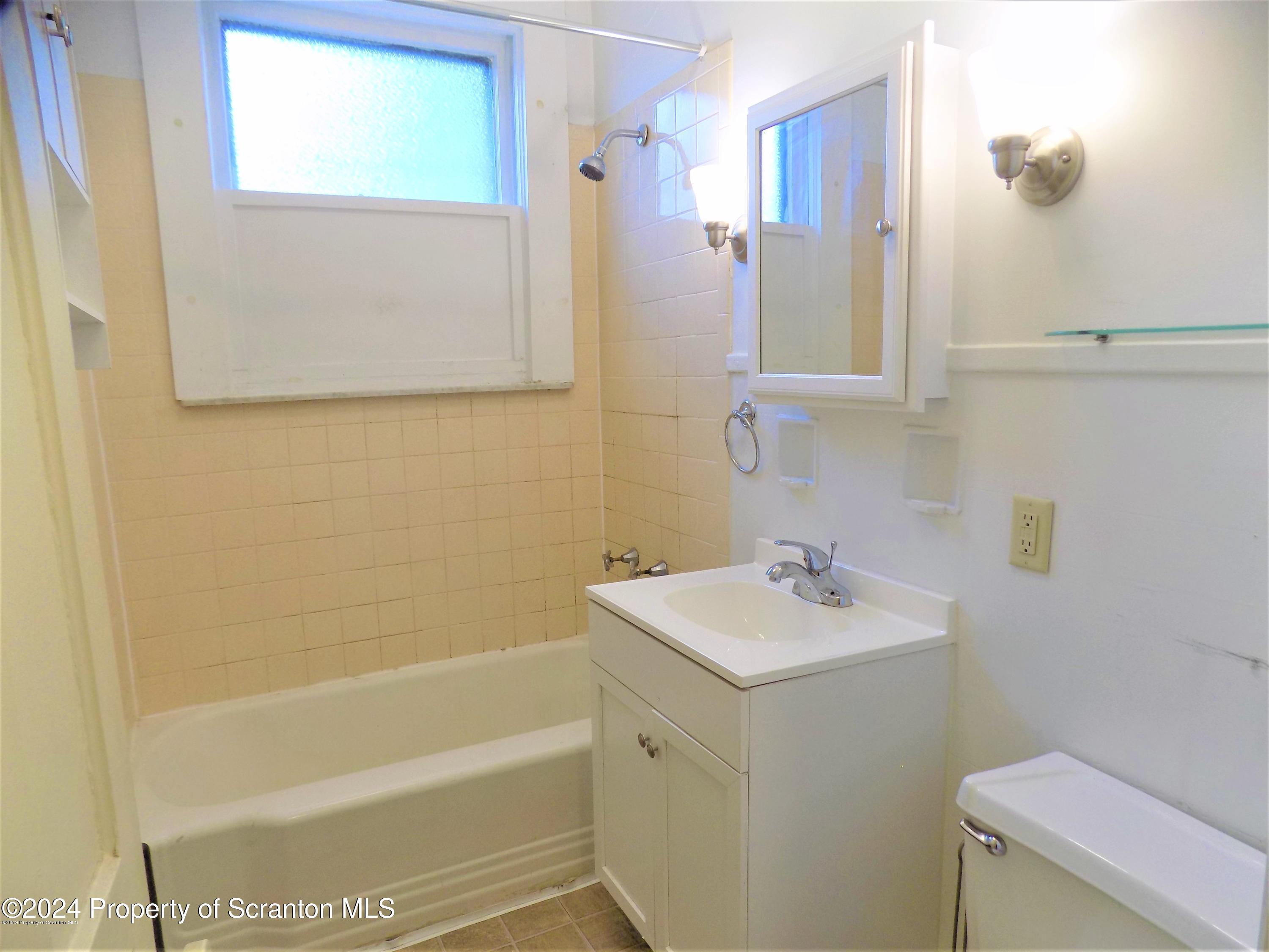 1543 Sanderson Avenue, Unit 1B Scranton, PA 18509 - Photo 5 of 12 a bathroom with a sink a toilet and shower