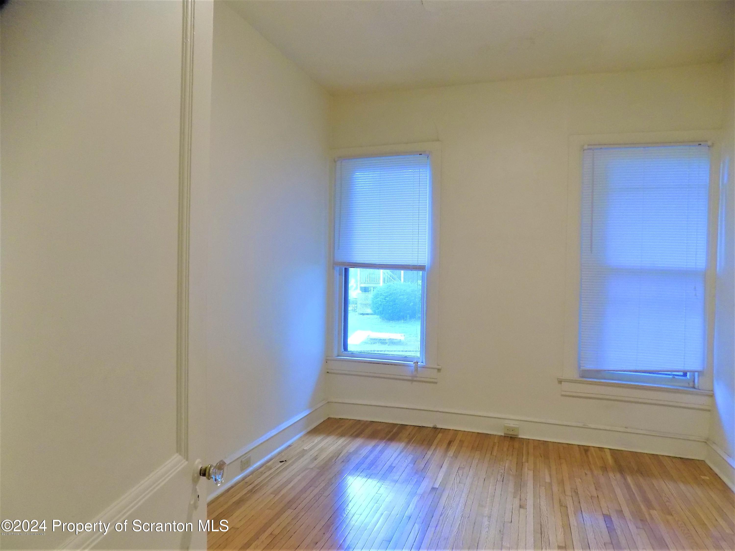 1543 Sanderson Avenue, Unit 1B Scranton, PA 18509 - Photo 7 of 12 a view of empty room with wooden floor and fan