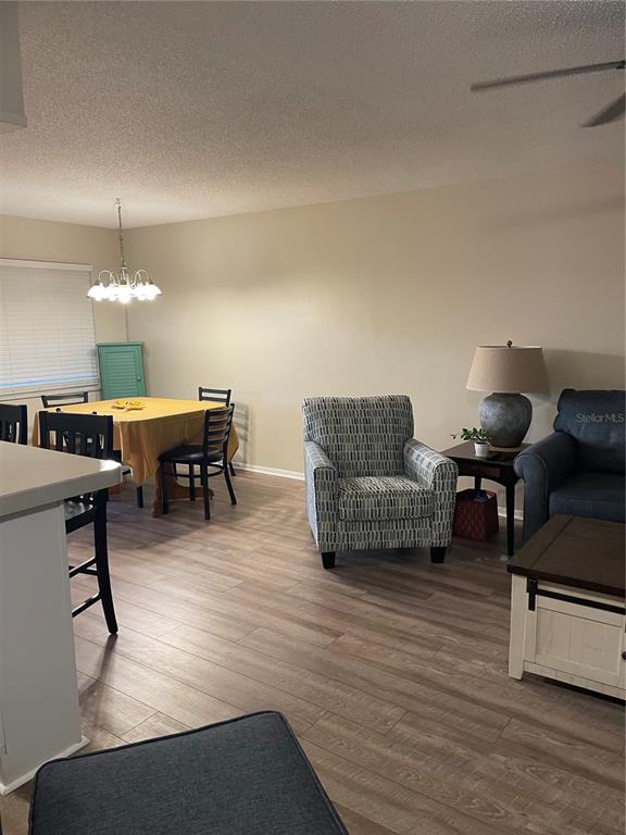 14531 Walsingham Road, Unit 203 Largo, FL 33774 - Photo 13 of 24 a living room with furniture and a chandelier