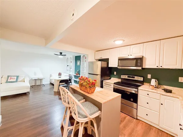 a kitchen with stainless steel appliances a stove a sink dishwasher and a stove with wooden floor