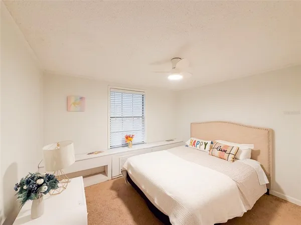 a bedroom with a bed and a potted plant