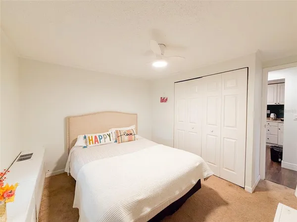 a bedroom with a bed and a refrigerator