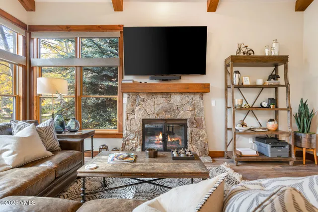 a living room with furniture a flat screen tv and a fireplace