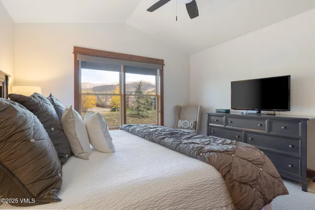 a bedroom with a bed and a flat tv screen on dresser