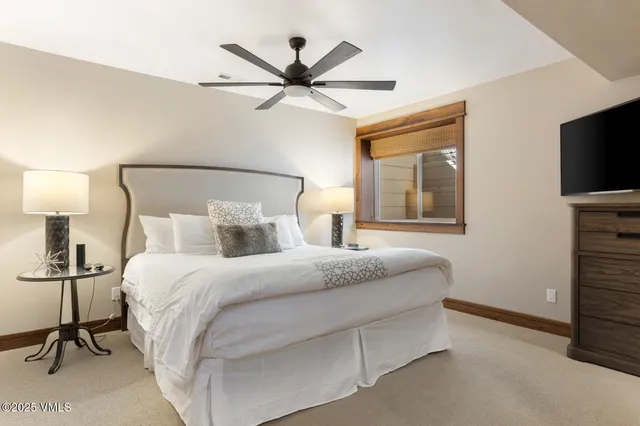 a bedroom with a bed and a flat tv screen on dresser