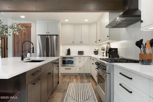 a kitchen with stainless steel appliances a sink stove and refrigerator