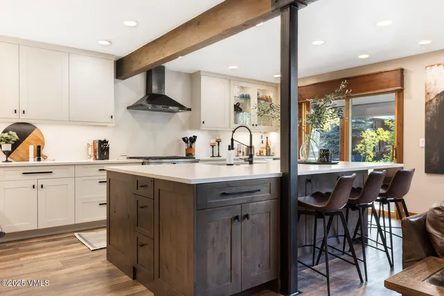 a kitchen with a sink a table and chairs in it