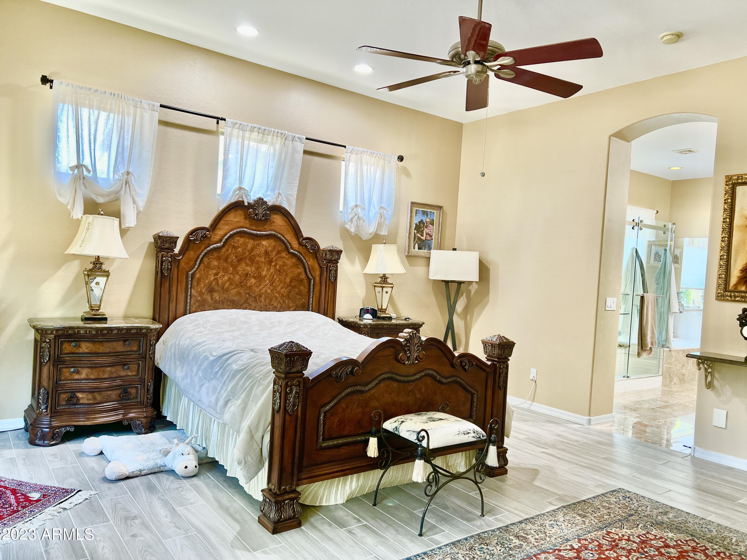 4735 South Rim Road Gilbert, AZ 85297 - Photo 19 of 38 a bedroom with a bed a mirror and lamp on the dresser