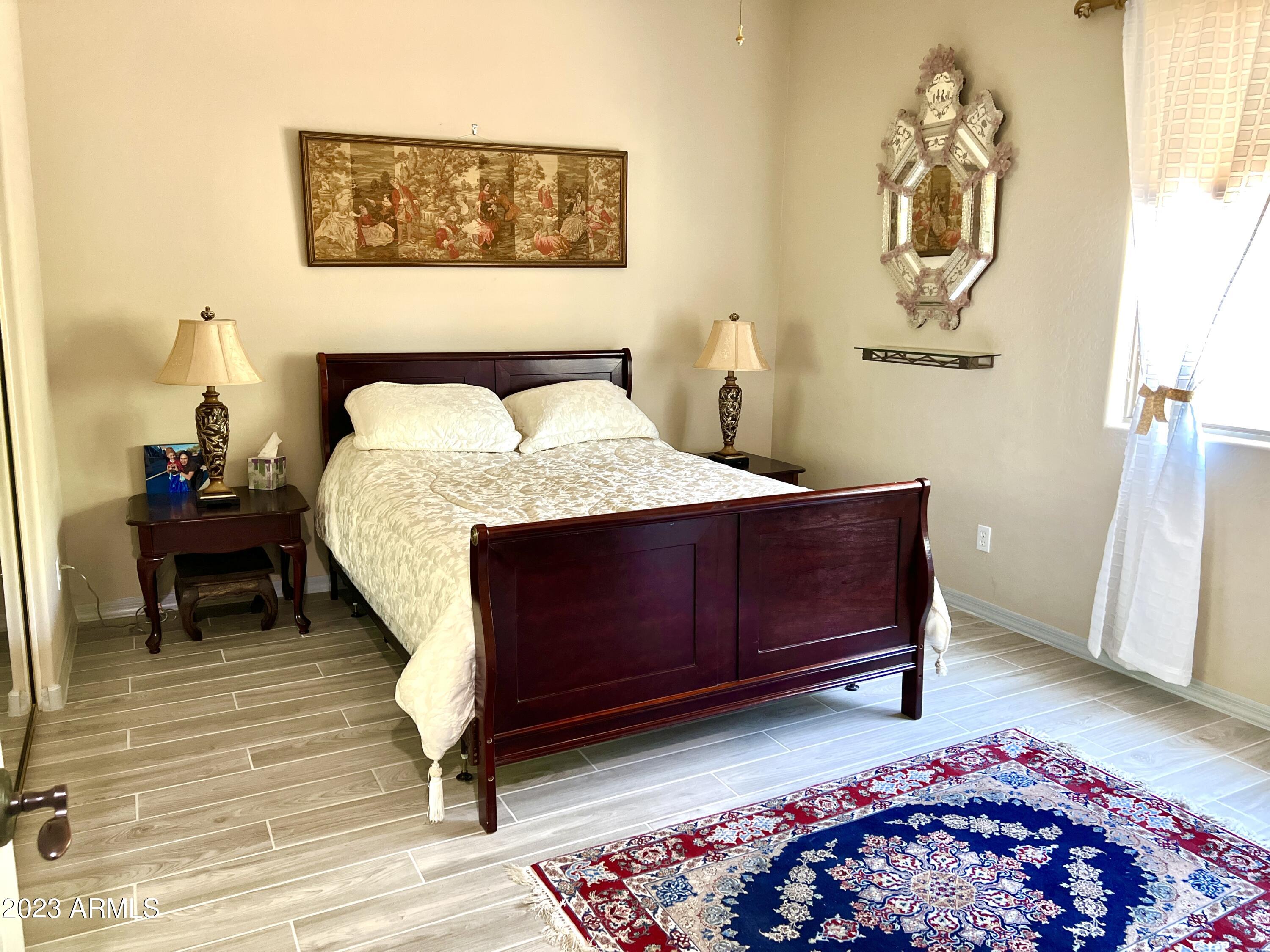 4735 South Rim Road Gilbert, AZ 85297 - Photo 26 of 38 a bedroom with a bed and wooden floor