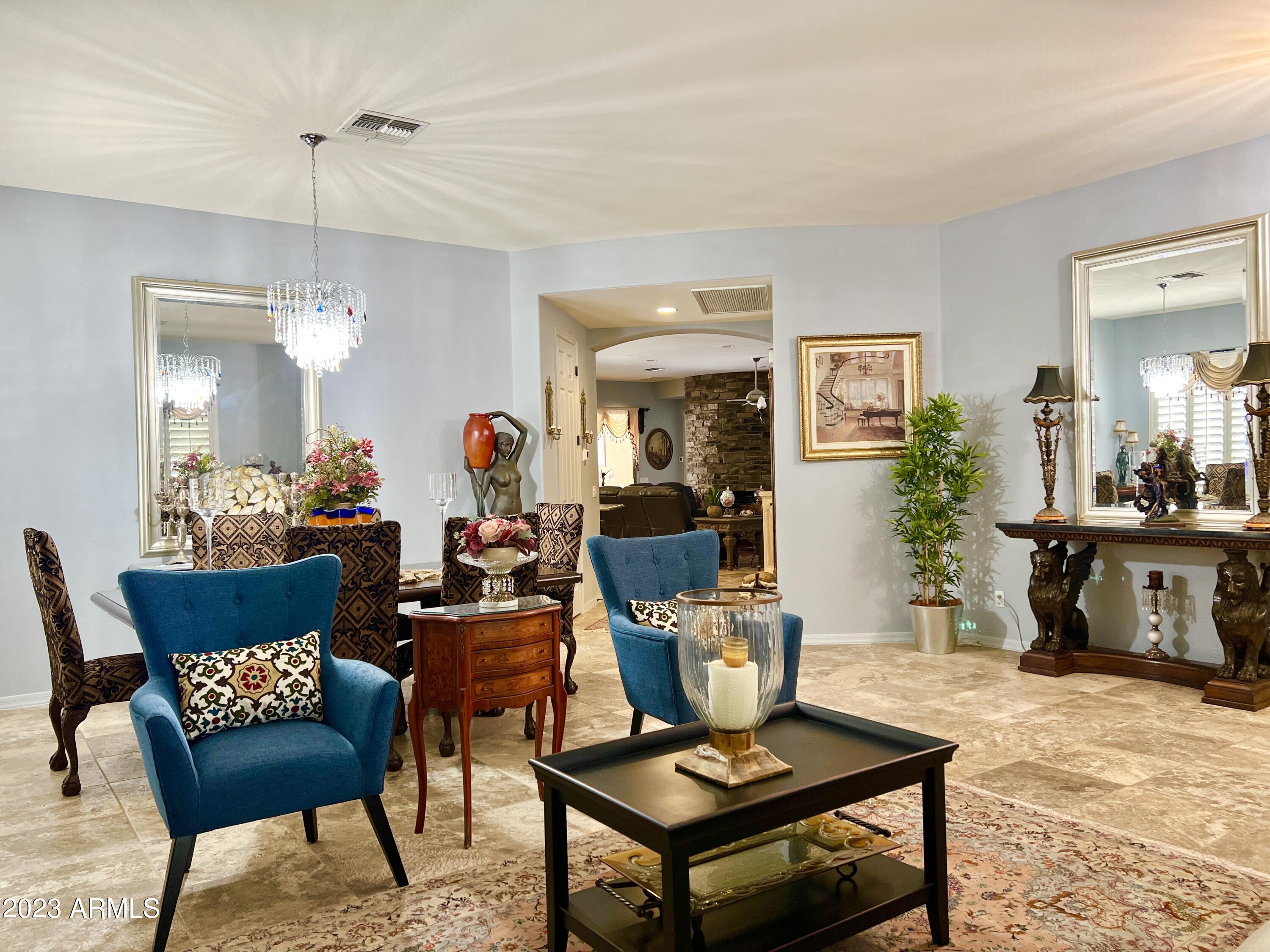 4735 South Rim Road Gilbert, AZ 85297 - Photo 7 of 38 a living room with furniture a rug and a chandelier
