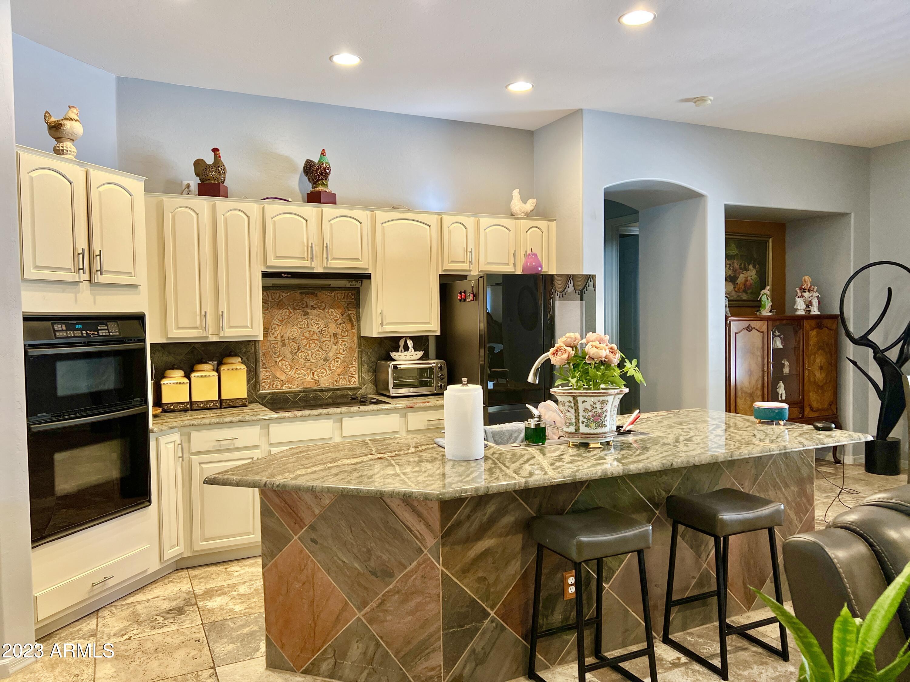 4735 South Rim Road Gilbert, AZ 85297 - Photo 9 of 38 a kitchen with stainless steel appliances granite countertop a stove top oven a sink and cabinets