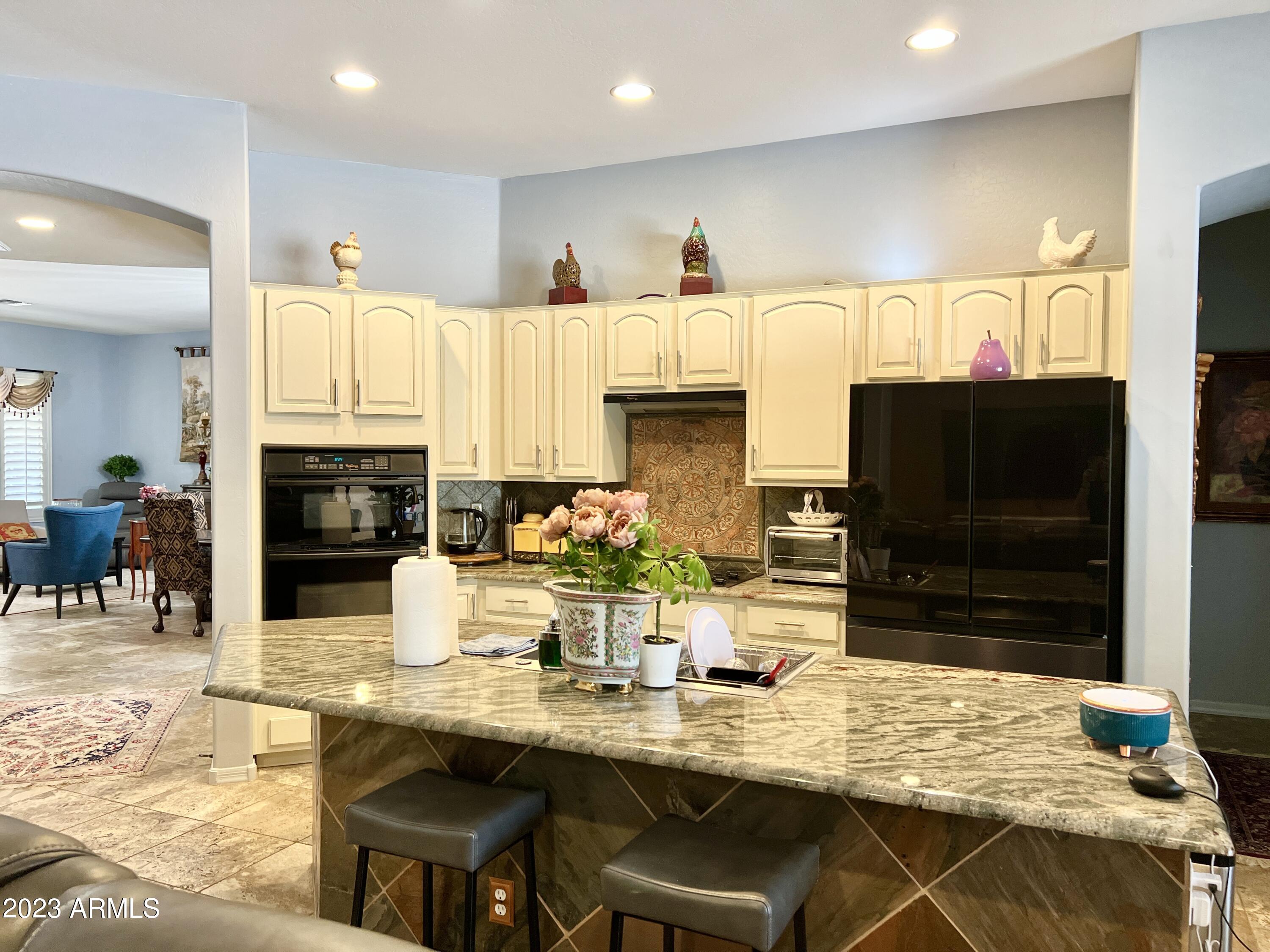 4735 South Rim Road Gilbert, AZ 85297 - Photo 10 of 38 a kitchen with stainless steel appliances kitchen island granite countertop a stove and cabinets
