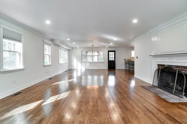 a view of a livingroom with wooden floor and a fireplace
