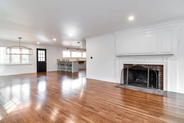 a view of a room with wooden floor and a kitchen
