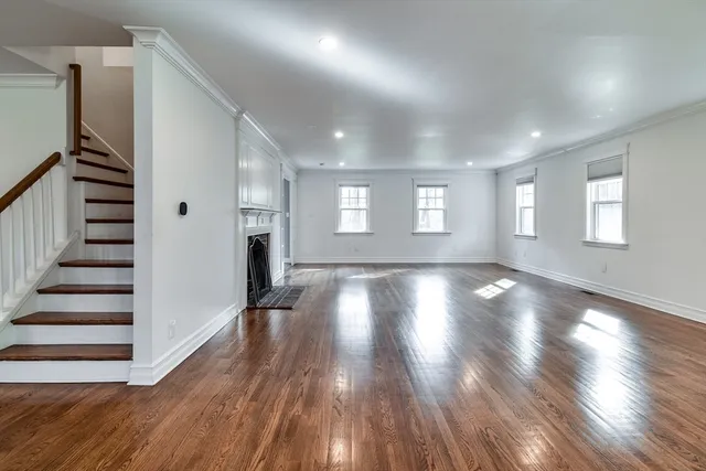 a view of empty room with wooden floor and window