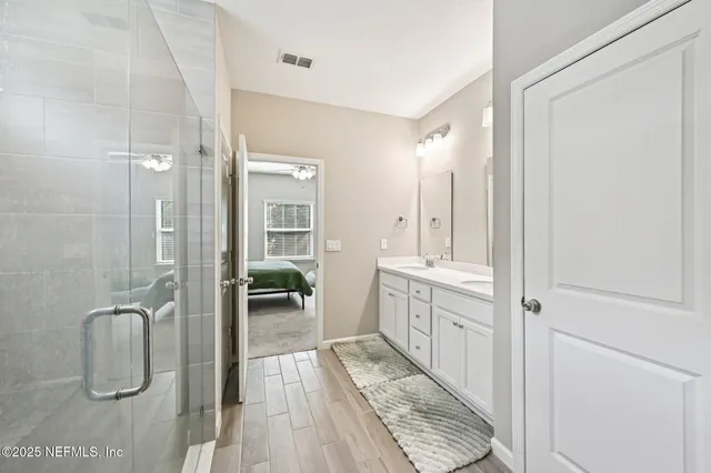 a bathroom with a double vanity sink a mirror and a shower