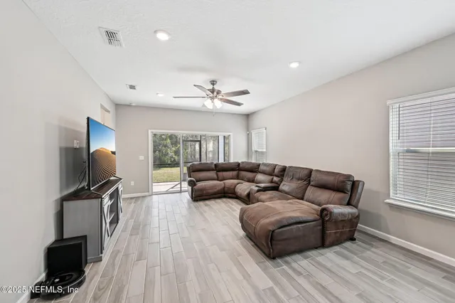 a living room with furniture a flat screen tv and a window