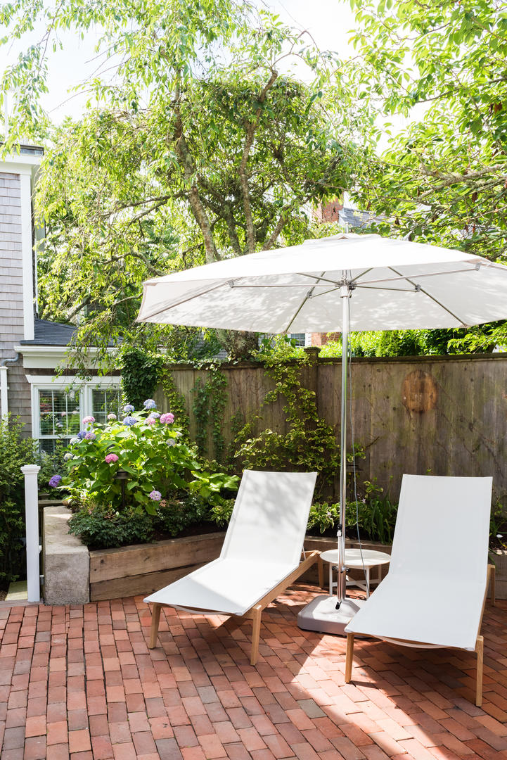59 Orange Street Nantucket, MA 02554 - Photo 42 of 42 a view of a patio with table and chairs under an umbrella