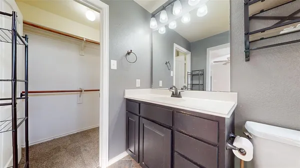 a bathroom with a sink a toilet a mirror and vanity