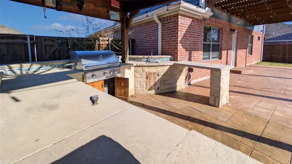 a view of a patio with table and chairs with wooden floor and fence