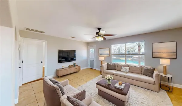 a living room with furniture a flat screen tv and a large window