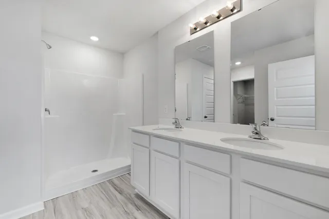 a bathroom with double sink and a mirror