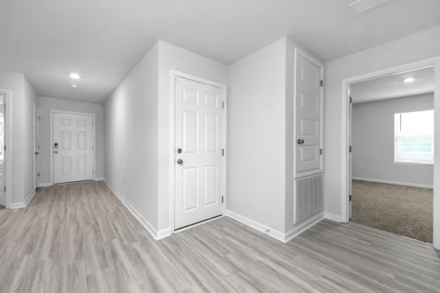an empty room with wooden floor & windows