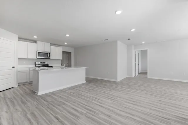 a view of kitchen with granite countertop cabinets and refrigerator