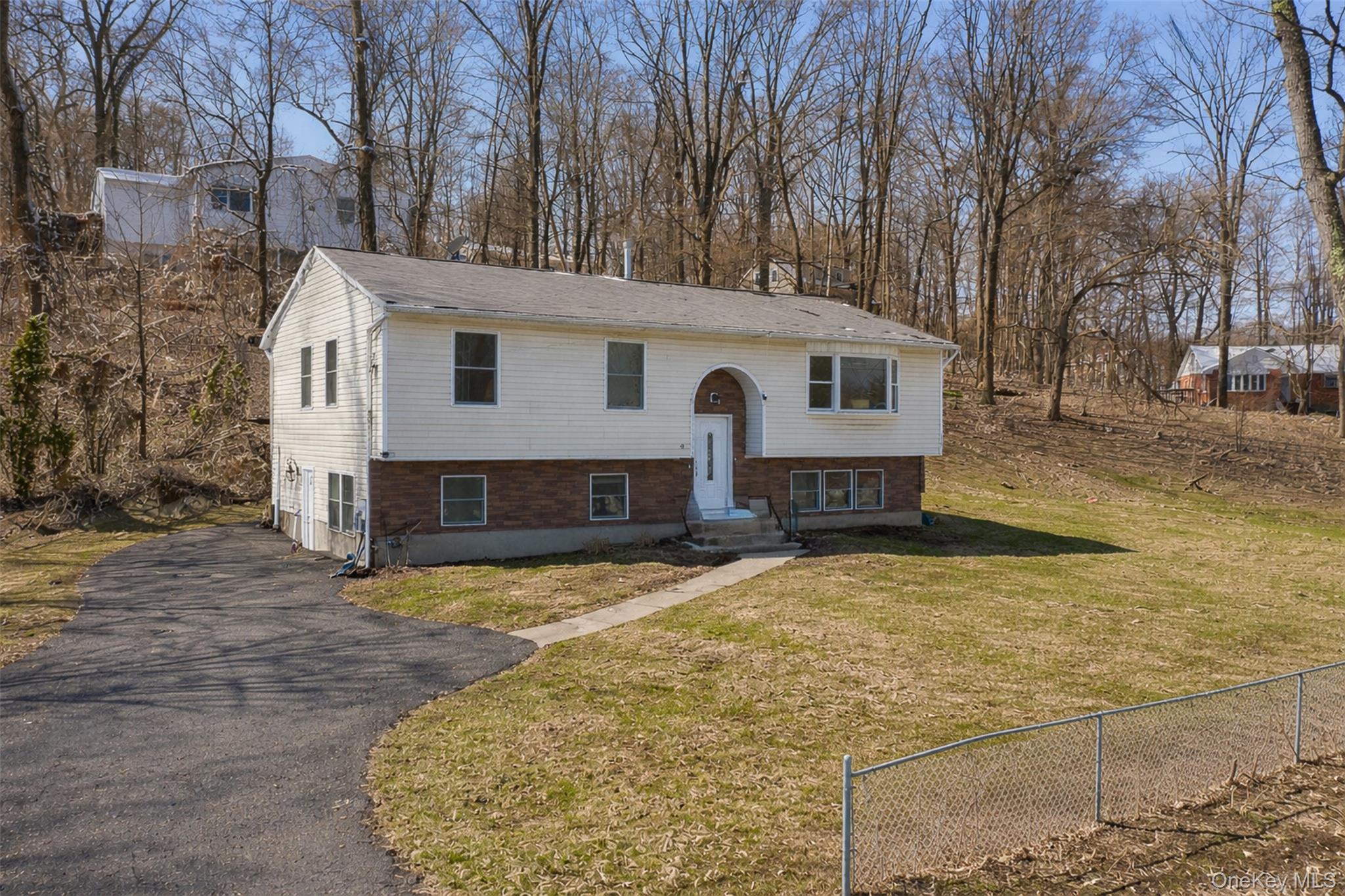a view of a house with a yard covered with snow and trees