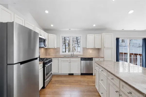 a kitchen with granite countertop a refrigerator stove top oven and sink