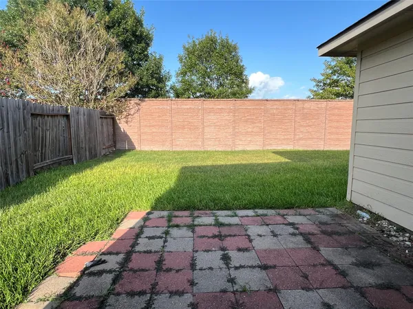 a view of yard with small space and wooden fence