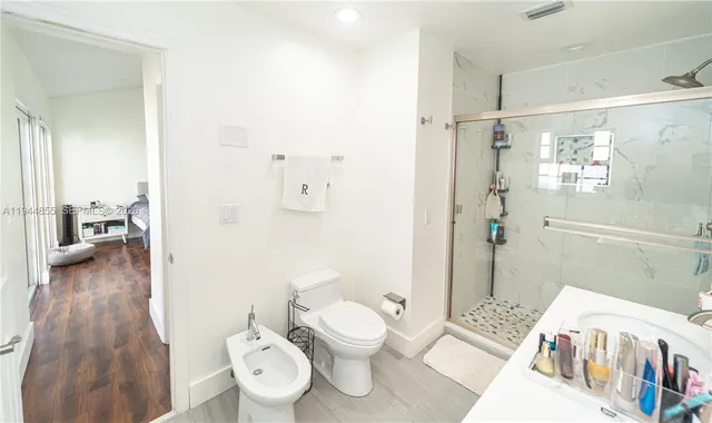 a bathroom with a sink a toilet and shower