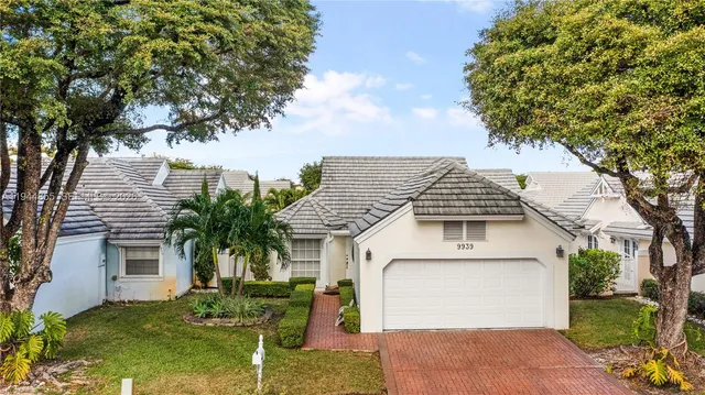 an aerial view of a house with a lake and a garden