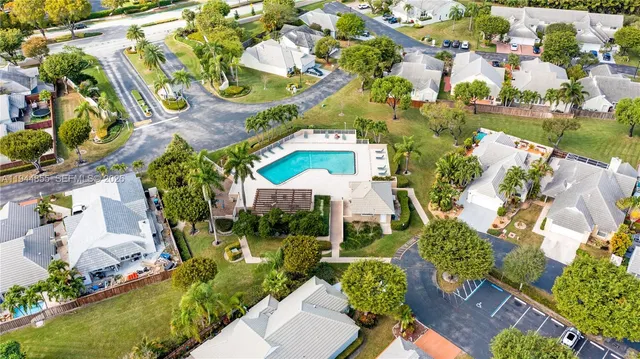 an aerial view of a city with lots of residential buildings ocean and trees in the background