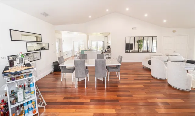 a view of a dining room with furniture a rug and wooden floor