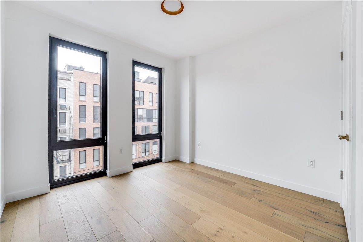 418 Monroe Street, Unit 201 Hoboken, NJ 07030 - Photo 14 of 29 an empty room with wooden floor and windows