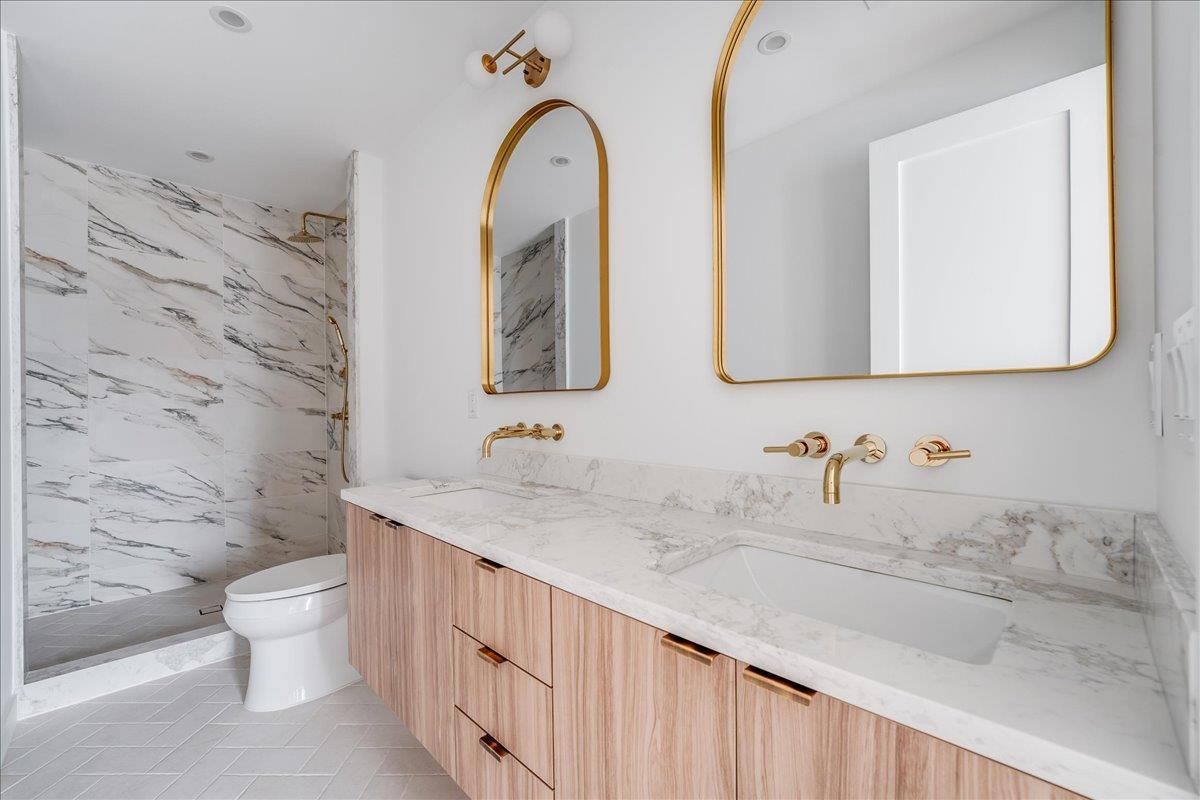 418 Monroe Street, Unit 201 Hoboken, NJ 07030 - Photo 15 of 29 a bathroom with a granite countertop toilet sink and mirror