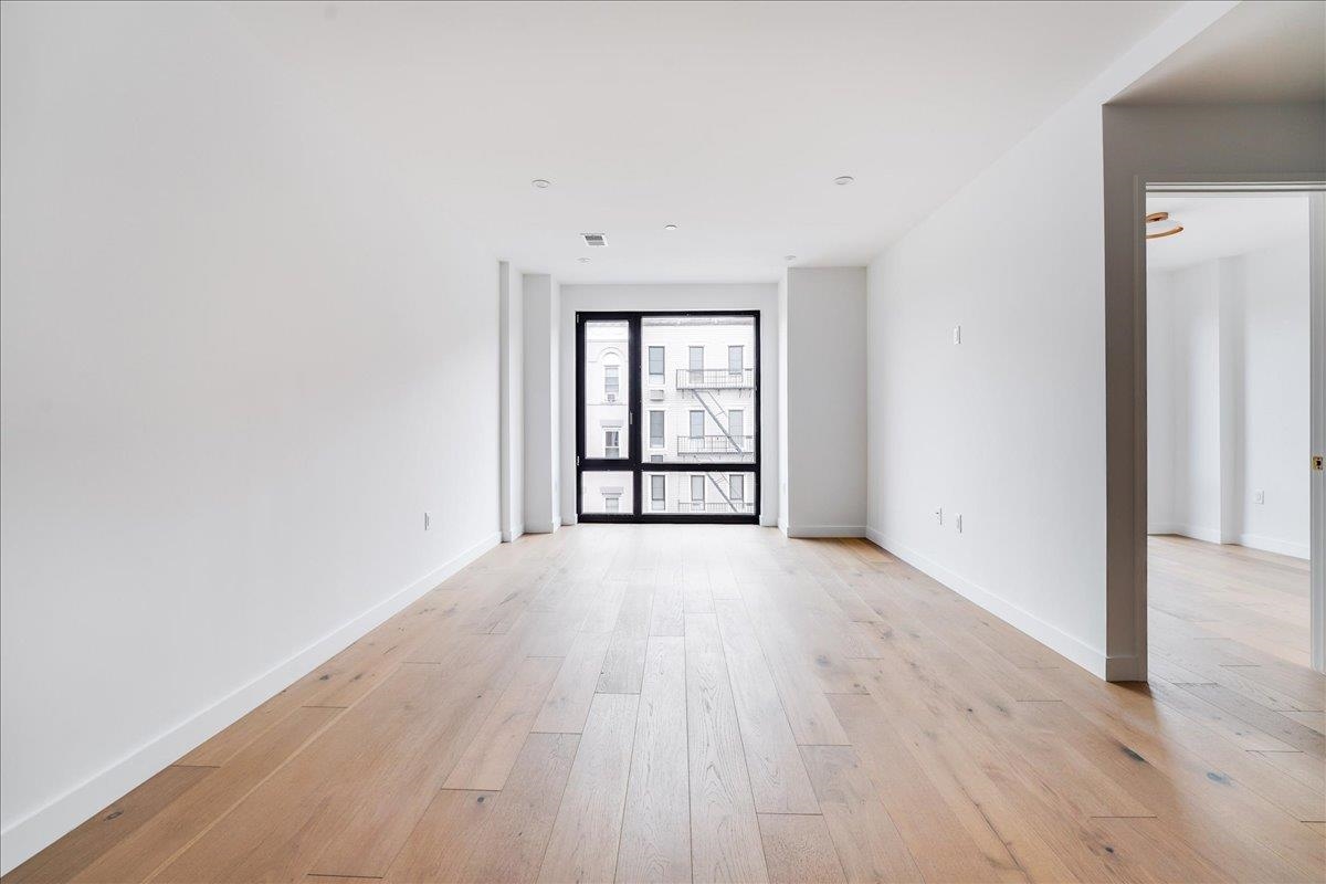 418 Monroe Street, Unit 201 Hoboken, NJ 07030 - Photo 17 of 29 an empty room with wooden floor and windows