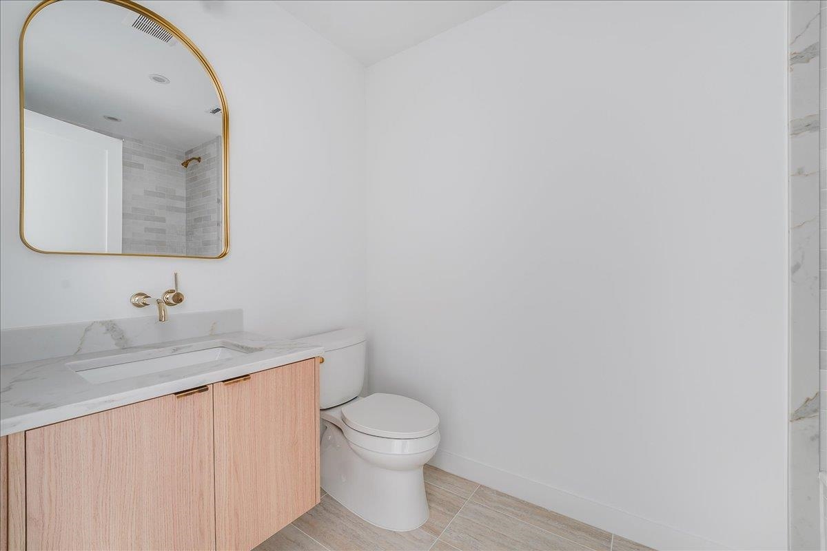 418 Monroe Street, Unit 201 Hoboken, NJ 07030 - Photo 21 of 29 a bathroom with a granite countertop toilet sink mirror and vanity