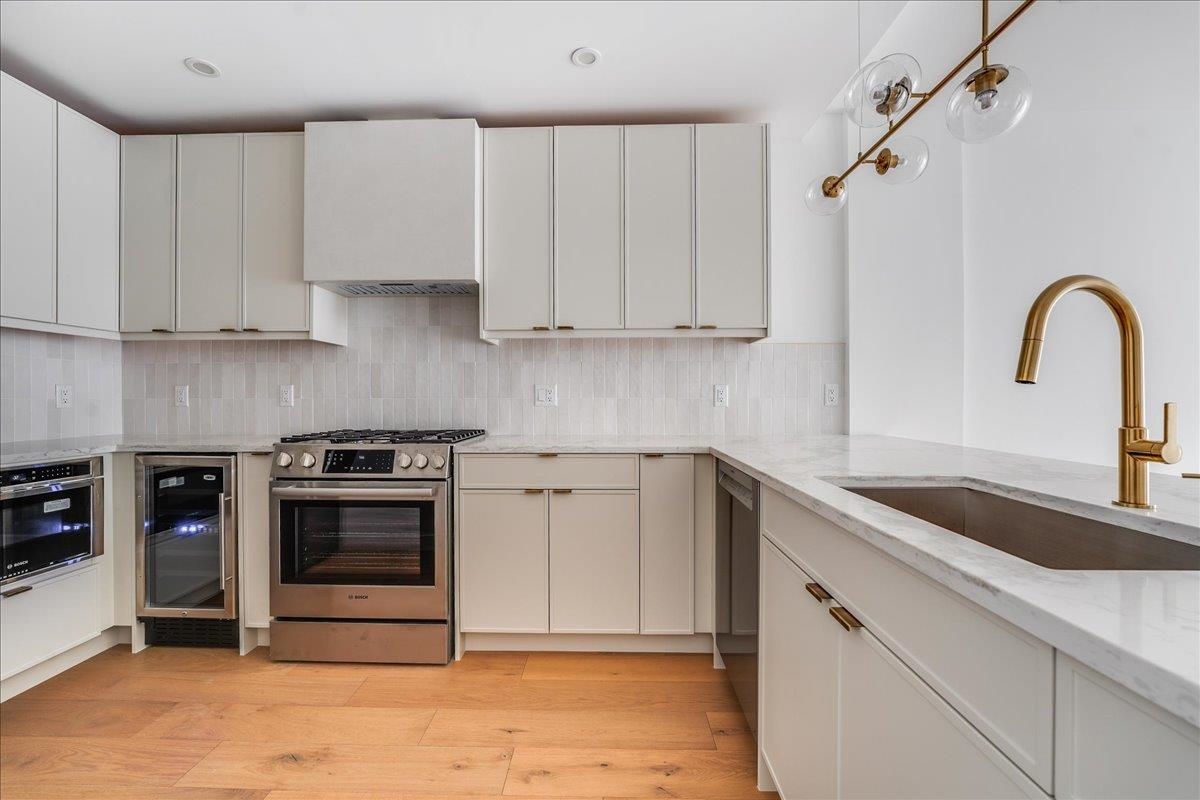 418 Monroe Street, Unit 201 Hoboken, NJ 07030 - Photo 4 of 29 a kitchen with granite countertop a sink stainless steel appliances and cabinets