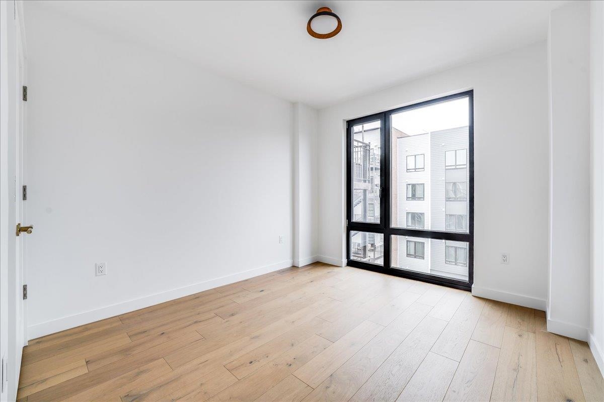 418 Monroe Street, Unit 201 Hoboken, NJ 07030 - Photo 10 of 29 an empty room with wooden floor and windows