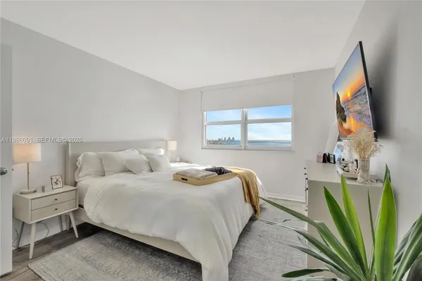 a bedroom with a bed and a flat screen tv